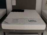 deux lits qui se trouvent dans une chambre et sur lesquels il n'y a pas de draps