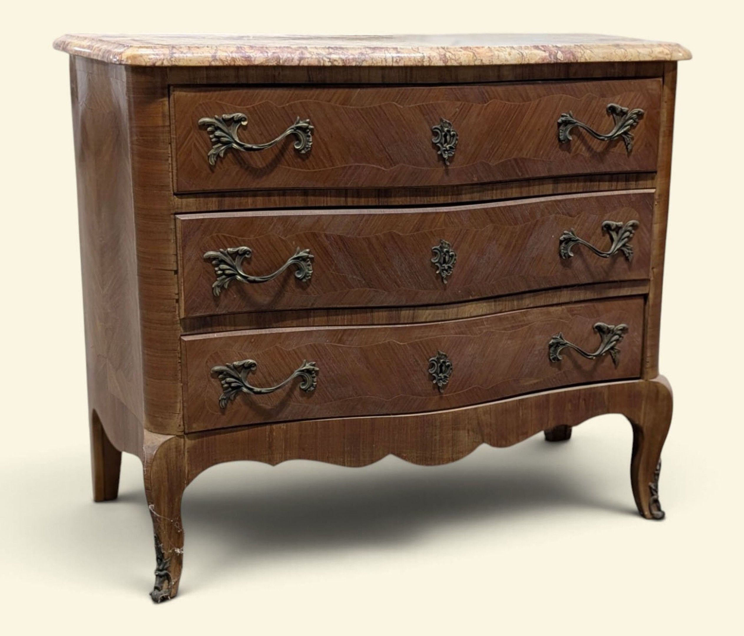 Commode galbée marquetée ouvrant par trois tiroirs en façade…