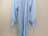 light blue blouse with ruffles on a hanger on a wall