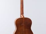 an acoustic guitar on a stand against a white background