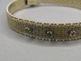 une photo d'un bracelet en or orné de pierres vertes
