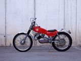 a red motorcycle parked in front of a white wall