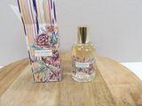 an image of a bottle of perfume sitting on top of a wooden table