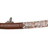 un très long couteau accroché au mur