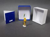 a small figurine of a man in a box next to a small box