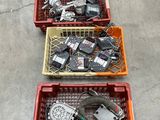 trois paniers remplis d'appareils électroniques divers, posés par terre
