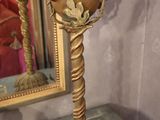 a gold vase on a table with a mirror in the background