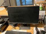 a desk with a computer, keyboard, mouse, and other items on it