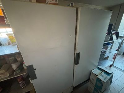 a white refrigerator in a room with a lot of boxes on the floor