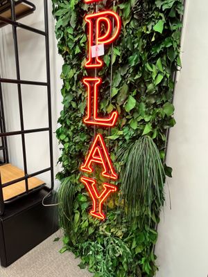 un mur vert avec une pancarte sur laquelle est écrit « play »