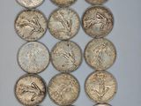 a bunch of silver coins sitting on top of a white surface