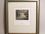 a framed picture of a group of horses walking down a dirt road