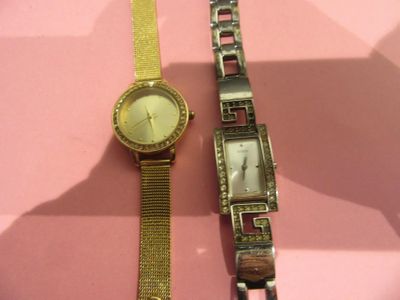 deux montres posées l'une à côté de l'autre sur une surface rose