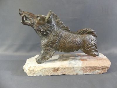 bronze statue of a dog on a stone base on a gray background