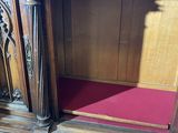 a wooden bench with a red cushion on top of it