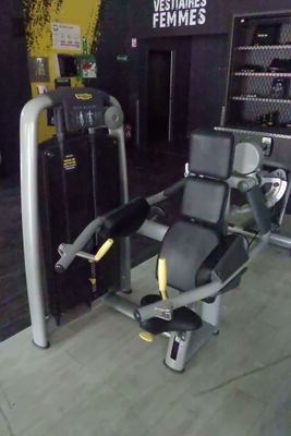 une photo d'une salle de sport avec un appareil et d'autres équipements