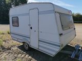 a small white trailer parked in a field