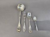 four silver spoons and two silver spoons on a gray surface