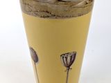 a yellow vase with a picture of a field of flowers on it