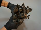 a person wearing black gloves holding a statue of a heart