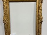 un miroir à cadre doré posé sur un socle en bois, sur fond blanc