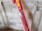 a red jack sitting on the ground next to a pile of wood