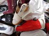a pile of shoes and bags sitting on the floor