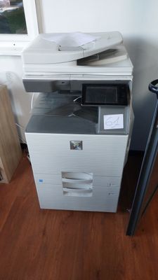 une imprimante posée sur un bureau, à côté d'une chaise