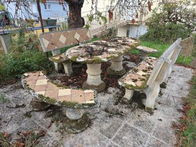 une table et des bancs en pierre au milieu de la cour