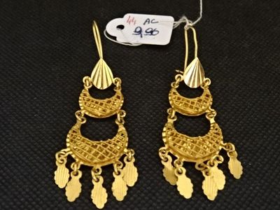 une paire de boucles d'oreilles en or ornées de franges sur fond noir