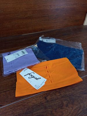 un tas de vêtements posé par terre à côté d'une paire de ciseaux