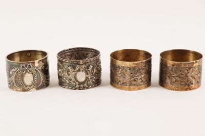 un lot de quatre serviettes en laiton ornées de motifs