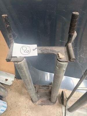 un poteau métallique sur lequel est accrochée une pancarte, à côté d'un tas d'outils