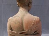 statue of a woman in a dress with a bird on her head