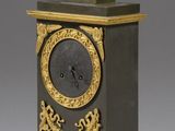 a black and gold clock with a bowl on top of it