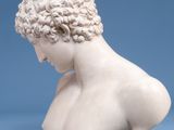 a white marble bust of a young man with curly hair
