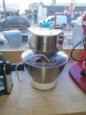 un robot de cuisine rouge posé sur un plan de travail à côté d'un autre robot de cuisine rouge