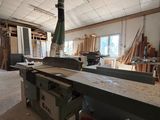 une grande table au milieu d'une pièce, sur laquelle sont posés de nombreux morceaux de bois