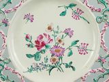 a white plate with pink and green designs on it