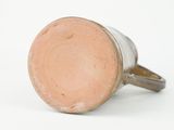 a close up of a brown cup on a white surface