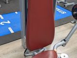 a gym machine with a red seat in the middle of the room