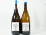 deux bouteilles de vin posées l'une à côté de l'autre sur une surface blanche