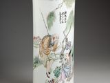 un vase blanc avec un tableau sur une table