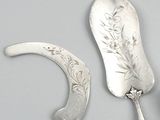 two silver spoons and a knife sitting on a table