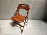 a wooden chair sitting against a wall in a room