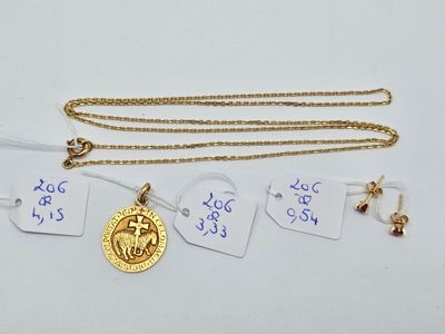 Gros plan sur un collier en or sur lequel se trouve une pièce de monnaie