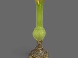 un vase ancien en verre vert posé sur un socle doré, sur fond gris