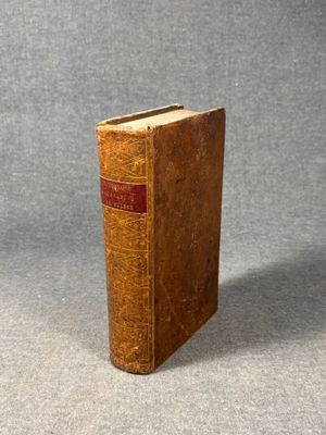 an old book sitting on top of a table next to a gray background