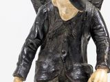 a figurine of a man with a bag on his back
