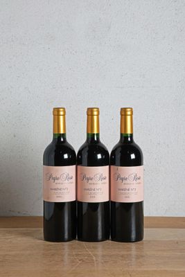 three bottles of wine sitting on top of a wooden table